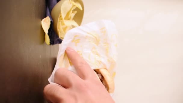 从装有薯片的纸袋中取出牛肉汉堡的垂直视频 — 图库视频影像