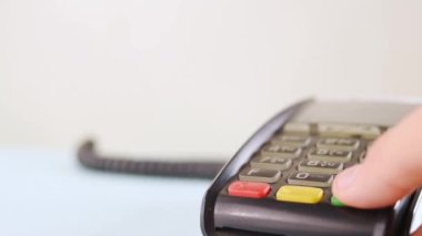 Veri bankasındaki kredi kartıyla ödeme yapan siyah tırnaklı bir el.