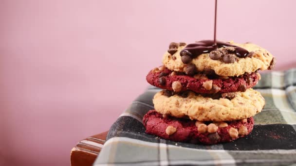 チョコレートソースが赤いチョコレートクッキーに落ちる — ストック動画