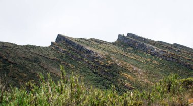 Rocky paramo landscape with fog and lake in a cloudy day
