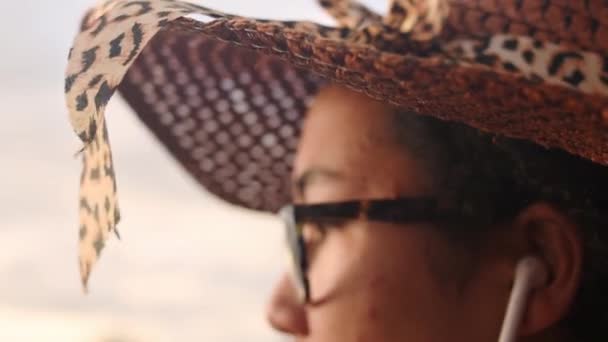 Женщина Плетеной Шляпе Снимает Наушники Солнечный День — стоковое видео