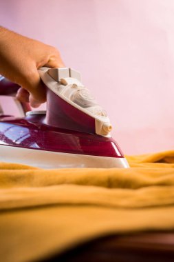 Sarı elbiseleri mor demiriyle ütüle.