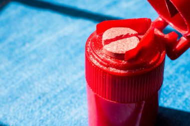 Kırmızıda kesilmiş haplar mavi arka planda ikiye bölünmüş.