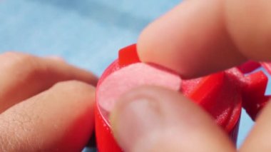 Mavi arka planda kesik hap kutusuyla el kesimi bir hap.