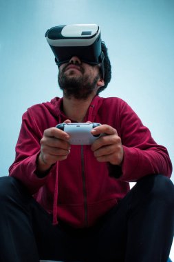 Oyuncu video oyunu denetleyicisiyle vr kulaklığında oynuyor