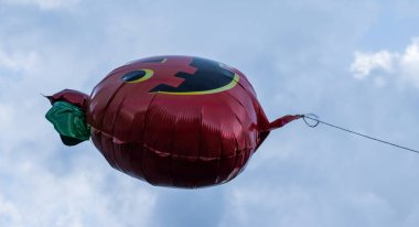 Bulutlu bir öğleden sonra yüzen Cadılar Bayramı balonu