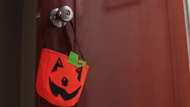 Hand Nimmt Eine Halloween Kürbistüte Von Einer Türklinke — Stockvideo