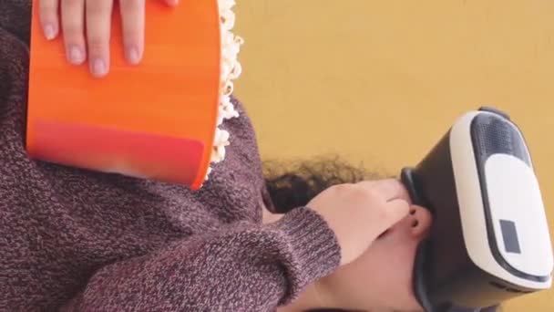 垂直录像 女人头戴Vr耳机 吃橙子罐的爆米花 — 图库视频影像