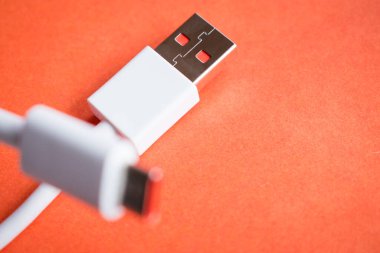 Turuncu arka planda beyaz usb kablosu