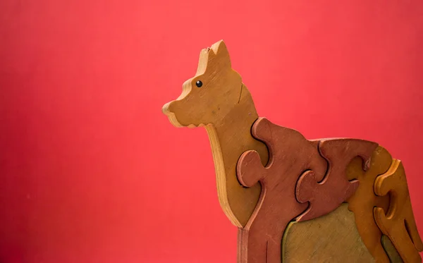 Wooden vintage dog puzzle on red background