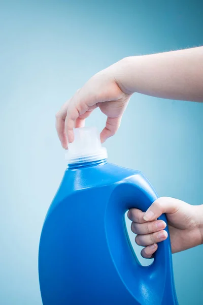 Mano Sosteniendo Una Botella Jabón Líquido Azul Sobre Fondo Azul — Foto de Stock