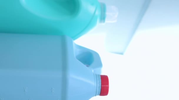 Вертикальное Видео Рука Берет Мыльную Бутылку Рядом Другими Голубыми Бутылками — стоковое видео