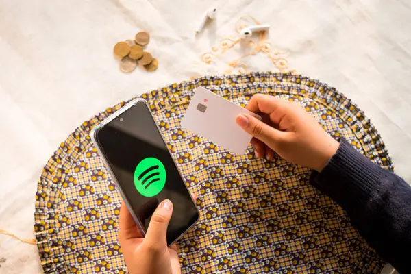 Kredi kartı tutan ve akıllı telefon ekranındaki logoyu bozan kadın