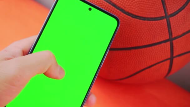 Hand Hålla Smartphone Med Grön Skärm Bredvid Orange Basket — Stockvideo