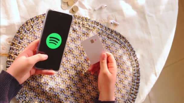 Kvinna Som Innehar Kreditkort Och Lämnar Smartphone Med Spotify Logotyp — Stockvideo