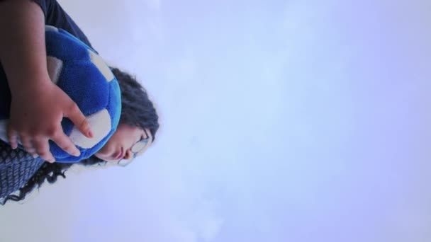 在多云的日子里 女人拿着蓝色足球 用Vuvuzela来支持球队的垂直视频 — 图库视频影像