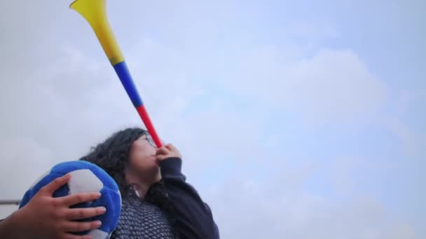 在多云的天气里 女人拿着蓝色的足球 用Vuvuzela来支持球队 — 图库视频影像
