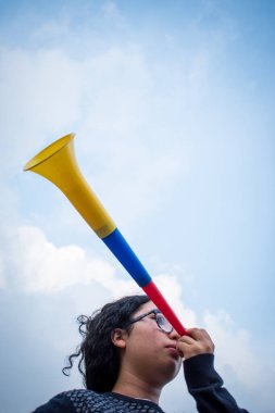 Bulutlu bir günde Vuvuzela kullanan bir kadın 