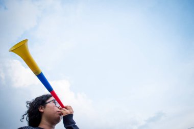 Bulutlu bir günde Vuvuzela kullanan bir kadın 