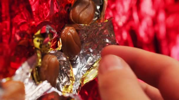 Vertical Video Man Taking Candy Golden Candy Packaging Red Background — Stock Video