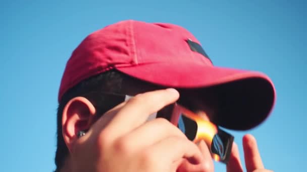 Portret Mężczyzny Noszącego Czapkę Okulary Przeciwsłoneczne Patrzącego Słońce Błękitnym Niebem — Wideo stockowe