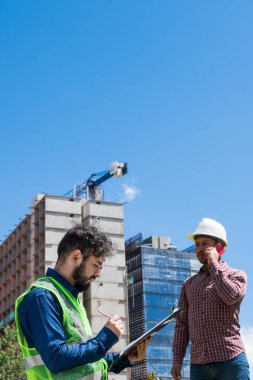 İnşaat işçileri güneşli bir günde inşaat alanında