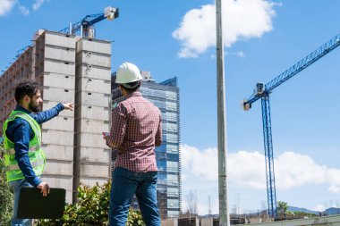 İnşaat işçileri güneşli bir günde inşaat alanında