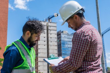 İnşaat işçileri güneşli bir günde inşaat alanında