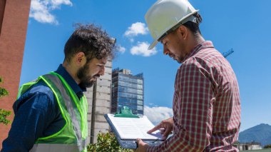 İnşaat işçileri güneşli bir günde inşaat alanında