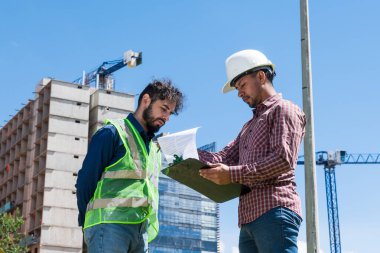 İnşaat işçileri güneşli bir günde inşaat alanında