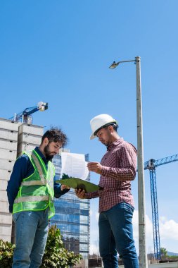 İnşaat işçileri güneşli bir günde inşaat alanında