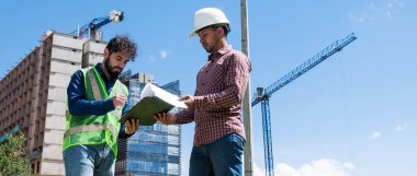 İş yerindeki işçiler inşaat sahasında anlaşma için bazı belgeleri imzalıyorlar