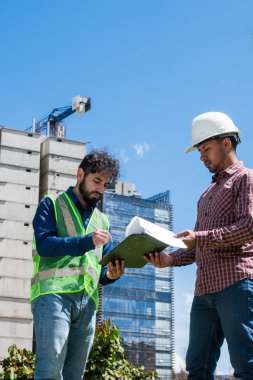 İş yerindeki işçiler inşaat sahasında anlaşma için bazı belgeleri imzalıyorlar