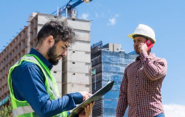 İnşaat işçileri güneşli bir günde inşaat alanında
