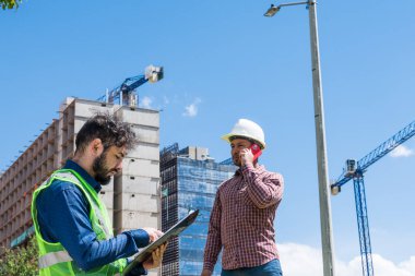 İnşaat işçileri güneşli bir günde inşaat alanında