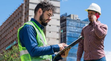 İnşaat işçileri güneşli bir günde inşaat alanında