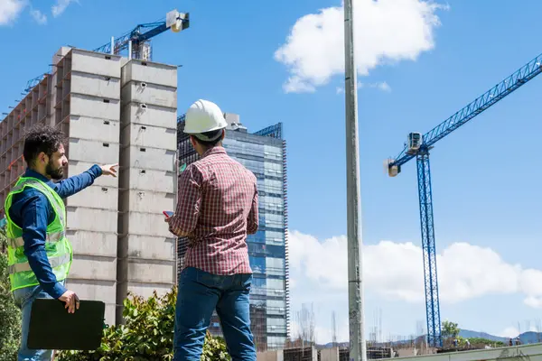 İnşaat işçileri güneşli bir günde inşaat alanında