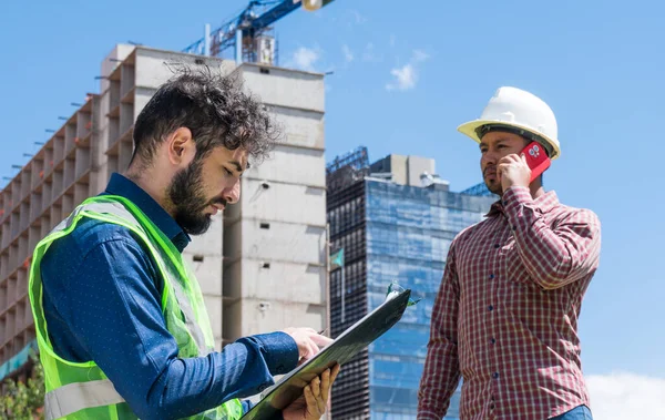 İnşaat işçileri güneşli bir günde inşaat alanında