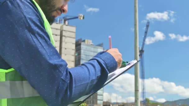 ラテン語の建設労働者 晴れた日の建設現場で文書を見ている男 — ストック動画