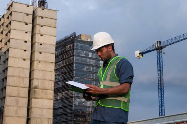  İşçi inşaat sahasında anlaşma için bazı belgeleri imzalıyor.