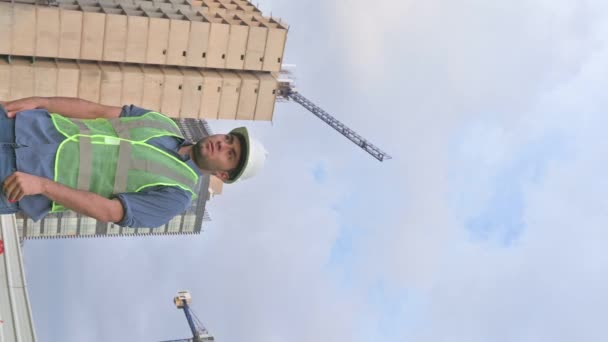 Pionowe Wideo Latynoskiego Robotnika Budowlanego Rozmawiającego Przez Telefon — Wideo stockowe