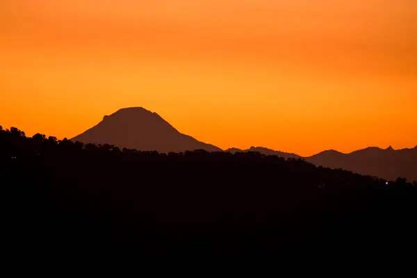 Landscape of yellow sunset of mountains silhouette