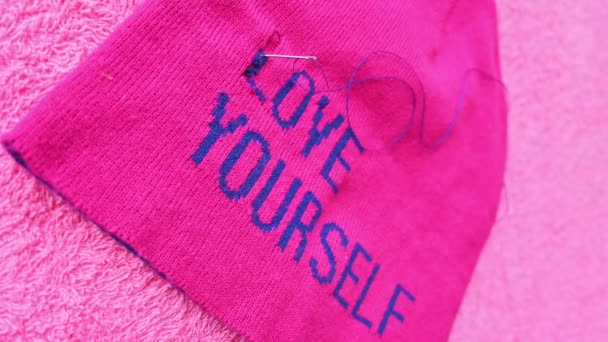 自己愛のメッセージとピンクの帽子に針を取る手の垂直ビデオ — ストック動画