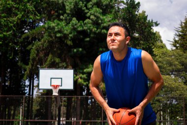 Yazın güneşli bir günde mahkemede basketbol antrenmanı yapan adam. 