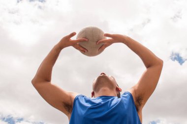 Güneşli bir günde voleybol oynayan bir adam.