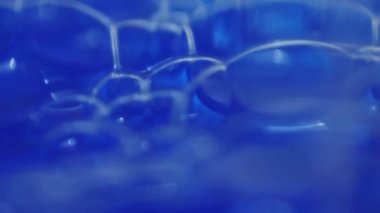 Çerçeveyi dolduran kabarcıklarla dolu mavi sıvı dokunun arkaplanı