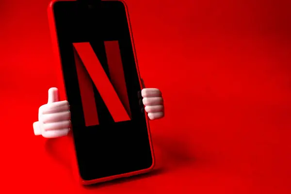 Netflix logosuna sahip akıllı telefon ekranda ve kırmızı arkaplanda