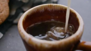 Kahve fincanında süt servisi, ağır çekimde.