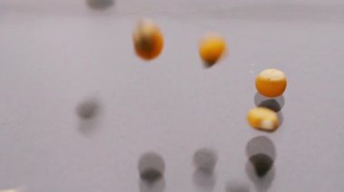 Cam yüzeyine düşen sarı patlamış mısır taneleri.