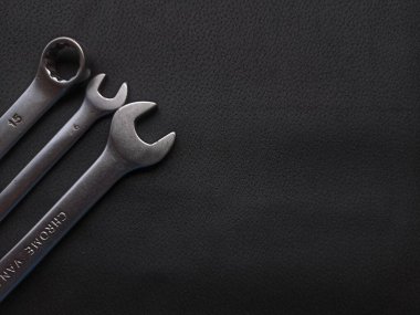 Siyah arka planda İngiliz anahtarı ve metal anahtarlar.